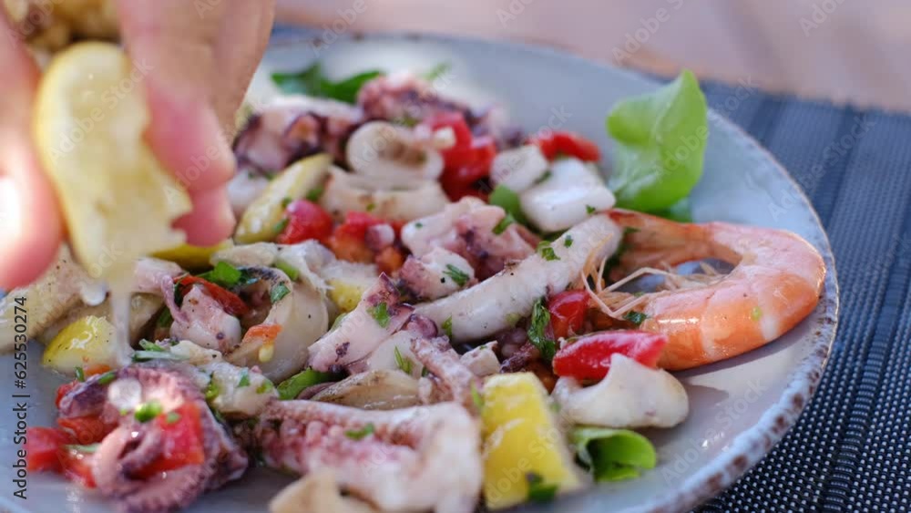 salad with seafood, squeezing lemon on the shores of the Adriatic Sea, Albania. High quality 4k footage salad with seafood, squeezing lemon on the shores of the Adriatic Sea, Albania. High quality 4k footage