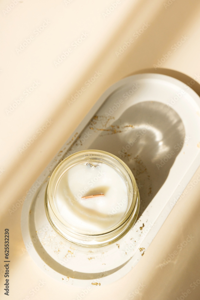 Handmade candle from paraffin and soy wax in glass with wooden wick isolated on pastel beige background. Flat lay, top view, copy space Handmade candle from paraffin and soy wax in glass with wooden wick isolated on pastel beige background. Flat lay, top view, copy space