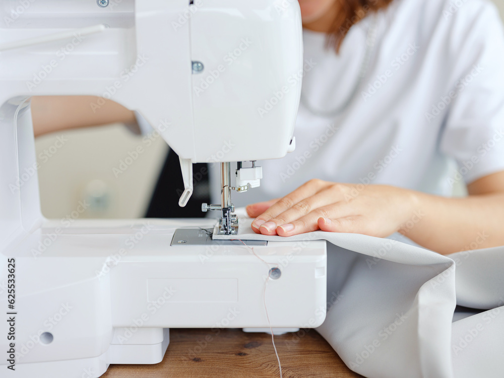 Fashion, fabric and sewing, woman at machine in small business with creative ideas and focus at home studio. Creativity, startup and design, tailor or designer stitching, young entrepreneur at work.