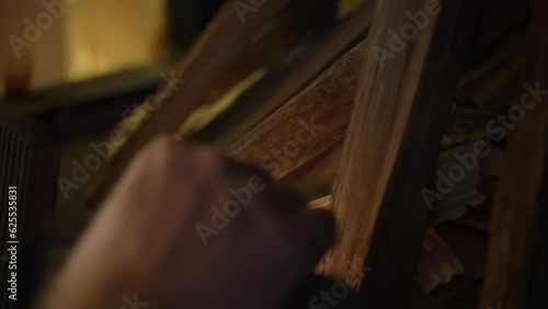 Lighting firewood in the fireplace with a match. Slow motion