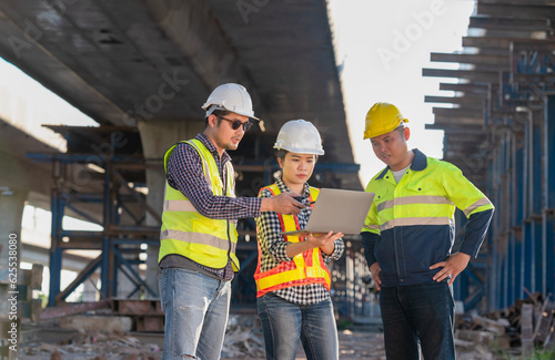 Team of 3 Asian engineers inspecting expressway construction. Asian architect and mature supervisor meeting at expressway construction site