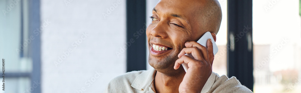 Obraz premium myasthenia gravis disease, bold african american man at work, cheerful and dark skinned office worker with ptosis syndrome talking on smartphone, inclusion, corporate culture, banner