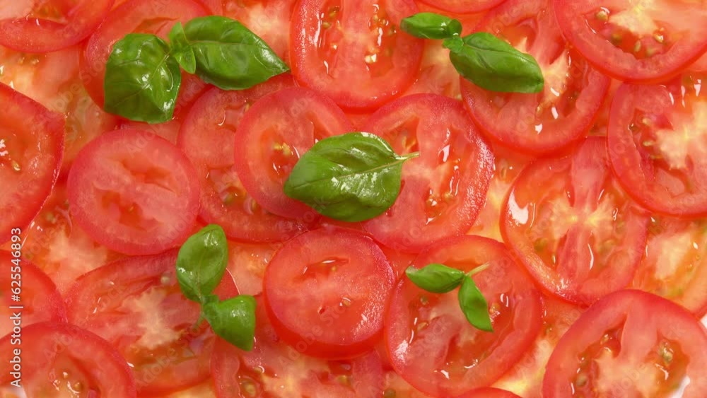 Sliced fresh tomatoes with fresh basil leaves like tomato carpaccio rotate as background. Preparations for pizza or vegetable salad. Tomato slices close up Sliced fresh tomatoes with fresh basil leaves like tomato carpaccio rotate as background. Preparations for pizza or vegetable salad. Tomato slices close up