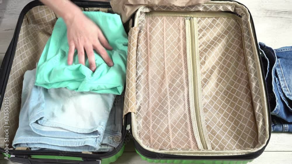 Man packing his suitcase for long journey with wad of money. Guy closes