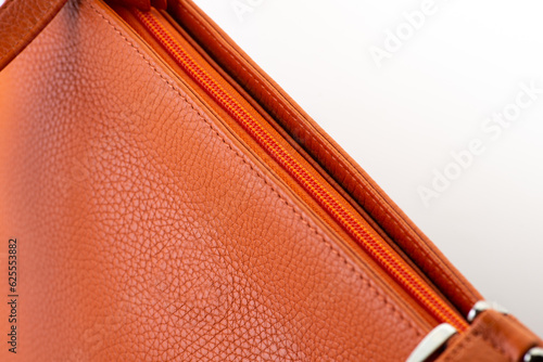 Close-up of a fashionable orange women's handbag on white background