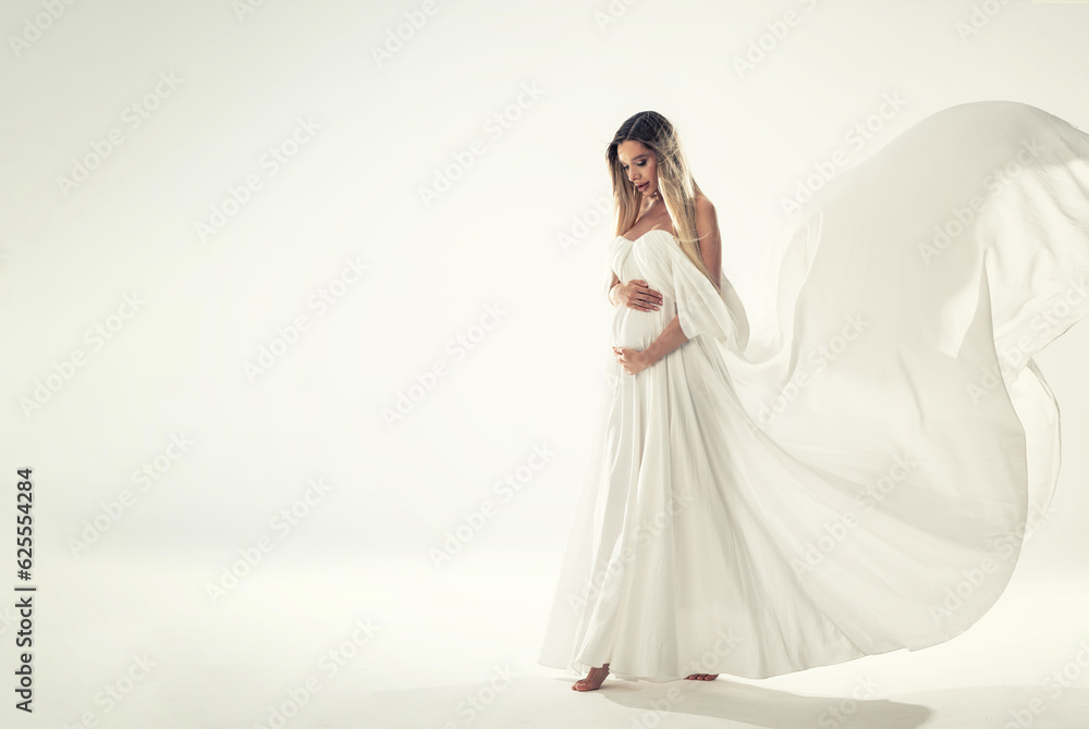 Beautiful Pregnant Woman holding her Belly wearing white, long Dress. Happy mom to be. A lot of copy space. Beautiful Pregnant Woman holding her Belly wearing white, long Dress. Happy mom to be. A lot of copy space.