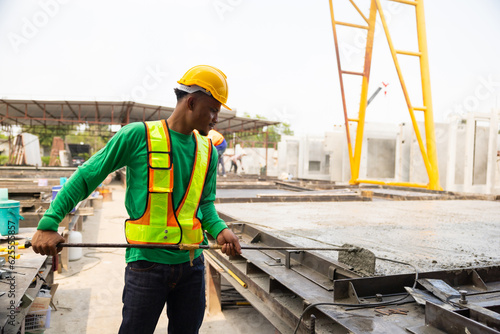 Fotografie African american mason worker pouring the ready-mixed concrete at Heavy Industry