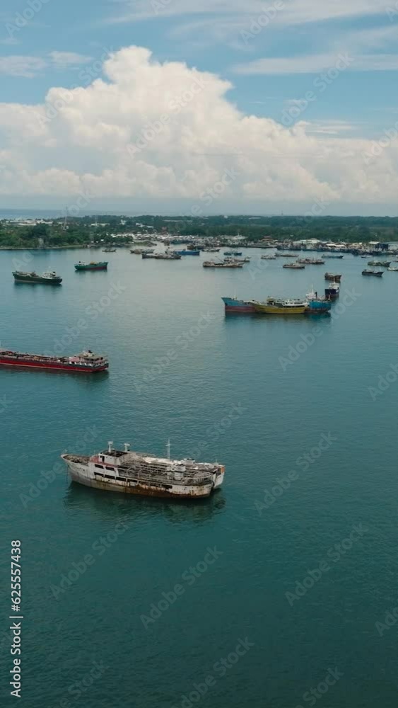 Groups of Fishing Boats floating and cargo ship over the sea in Zamboanga. Mindanao, Philippines. Seascape. Aerial drone view. Vertical video. Groups of Fishing Boats floating and cargo ship over the sea in Zamboanga. Mindanao, Philippines. Seascape. Aerial drone view. Vertical video.