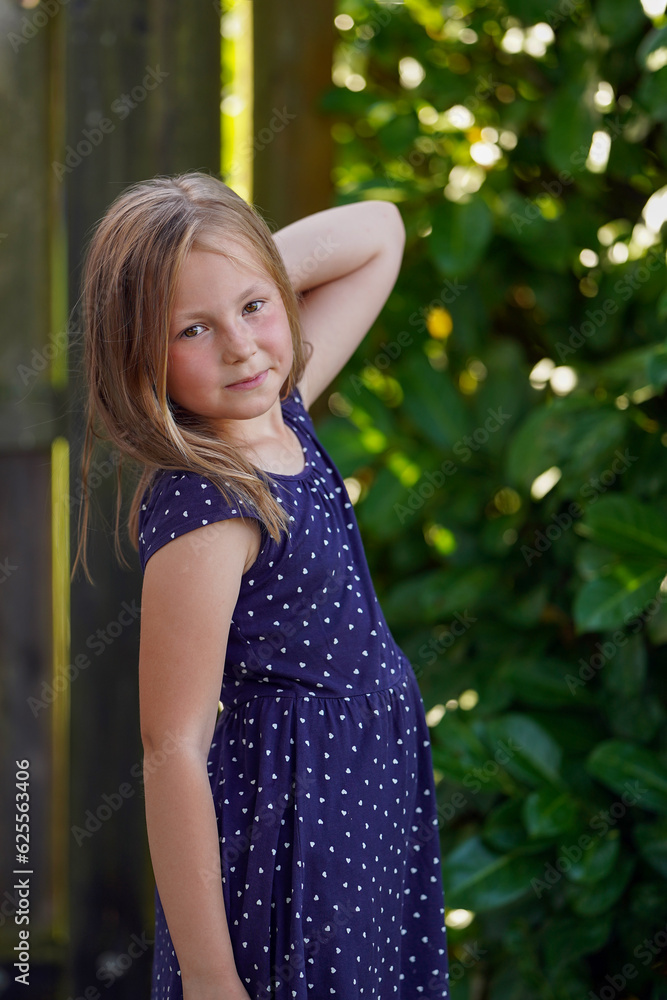 Fototapeta premium Portrait of a cute rural girl in a polka dot dress.