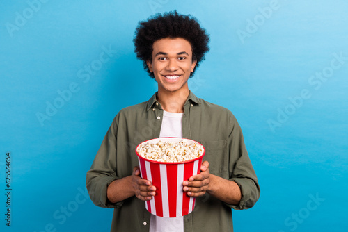 Fotografia Portrait of optimistic friendly guy with perming coiffure wear khaki shirt holdi