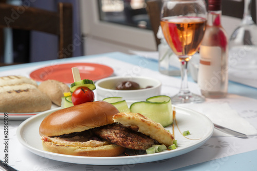 Fine casual dining: classic burger with cucumber slices served on the restaurant table