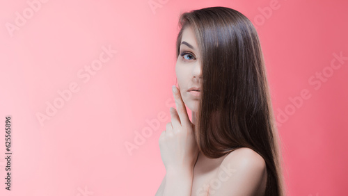 Beauty portrait of brunette with perfect hair, on a pink background