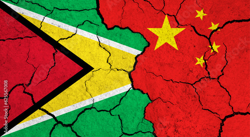 Flags of Guyana and China on cracked surface - politics, relationship concept