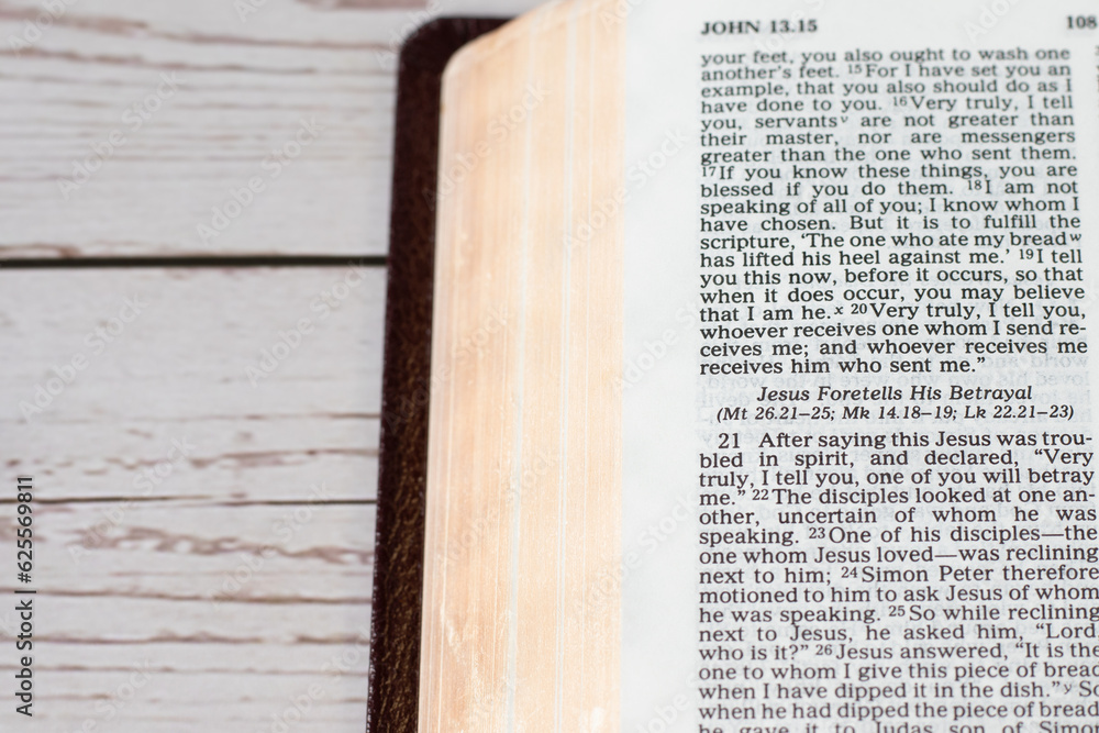 Obraz premium Jesus Christ's betrayal, biblical verses in open holy bible book on wooden table. A close-up.