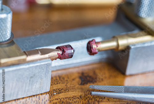 Transferring process from one to another metal dop of the red garnet stone during gems stone cutting process of the crown