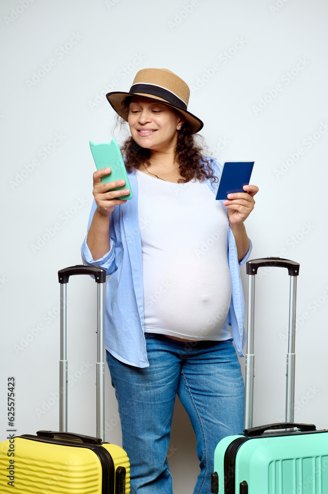 Happy pregnant woman checks her flight on mobile app using her smartphone, going on summer vacations, isolated on white Happy pregnant woman checks her flight on mobile app using her smartphone, going on summer vacations, isolated on white