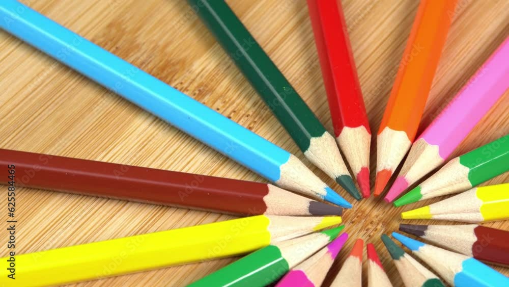 Colorful pencils rotate as sun rays background. Rainbow pencils for drawing. Assortment of colored pencils. Back to school concept Colorful pencils rotate as sun rays background. Rainbow pencils for drawing. Assortment of colored pencils. Back to school concept