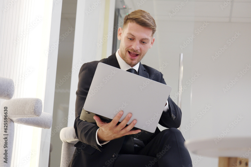 Businessman in a suit sitting on the couch working on a laptop. Businessman in a suit sitting on the couch working on a laptop.