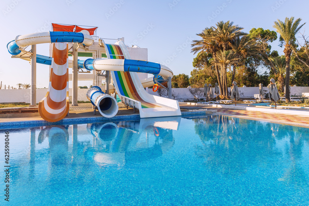 Empty small aquapark sliders with pool and palm trees at the morning, Tunisia
