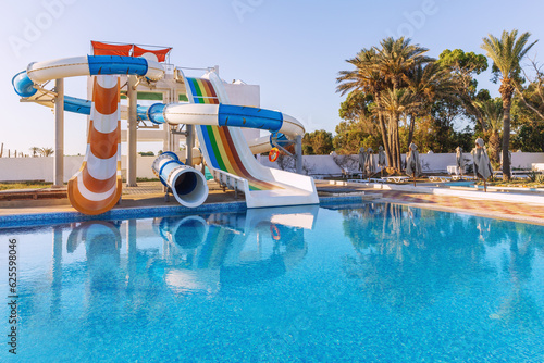 Obraz na płótnie Empty small aquapark sliders with pool and palm trees at the morning, Tunisia w salonie