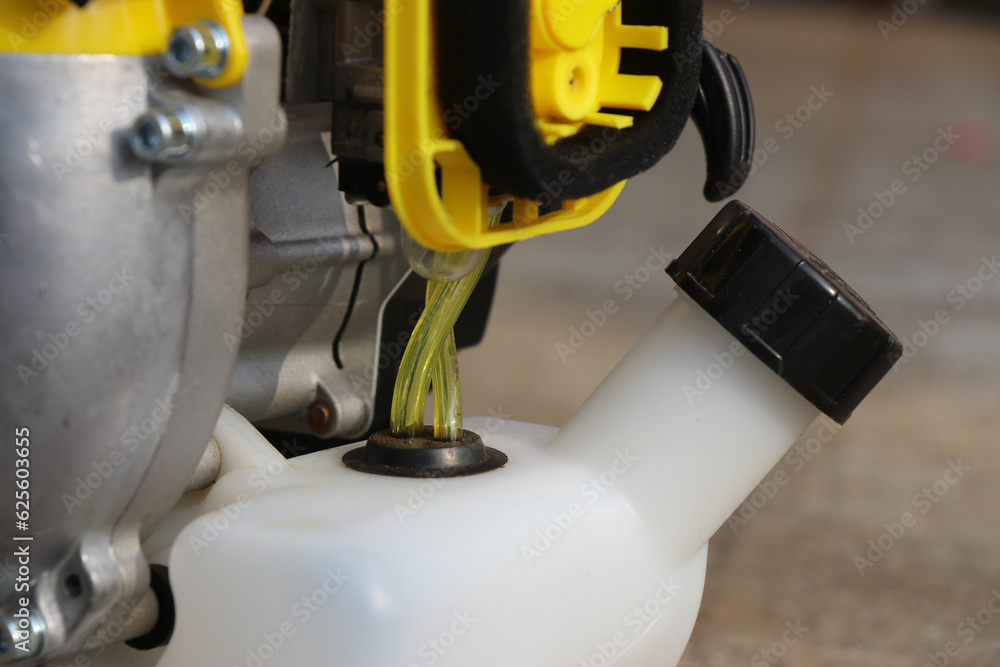 Close up of Gasoline pump hose for fuel supply in a brush trimmer. Parts of a petrol powered bush trimmer with a view of carburetor and gas tank