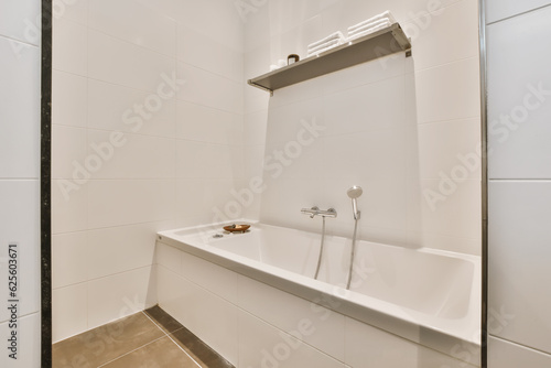 a bathroom with white tiles and black trim around the tub  sink  and faucet in it s corner