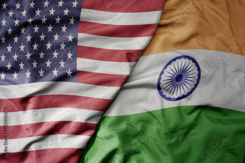 big waving colorful flag of united states of america and national flag of india .