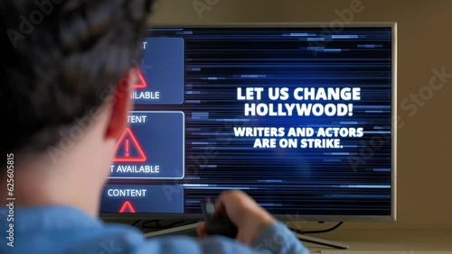 Man emotionally turns on TV channels with Hollywood Strike Warning on it photo
