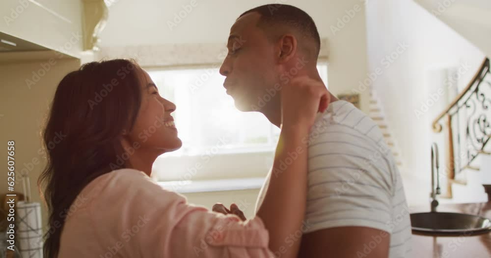Happy biracial couple dancing together in kitchen Happy biracial couple dancing together in kitchen