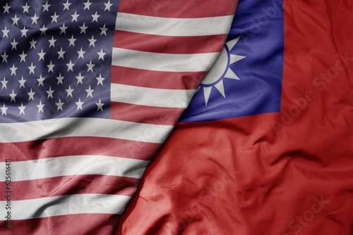 big waving colorful flag of united states of america and national flag of taiwan .