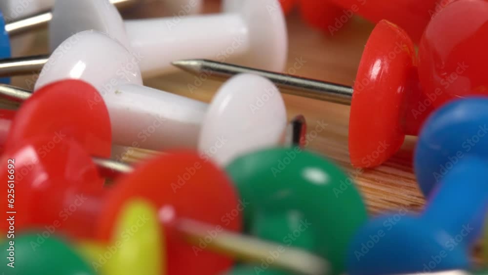 Colorful push pins rotating on the table macro. Drawing pins for marking on the map of the Earth or city. Plastic pins Colorful push pins rotating on the table macro. Drawing pins for marking on the map of the Earth or city. Plastic pins