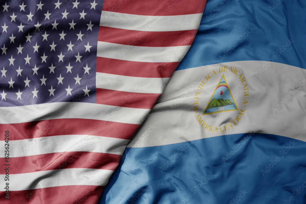 Obraz premium big waving colorful flag of united states of america and national flag of nicaragua .