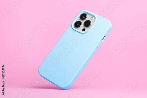 iPhone 15 Pro in blue soft silicone case falls down back view, phone case mockup isolated on pink background