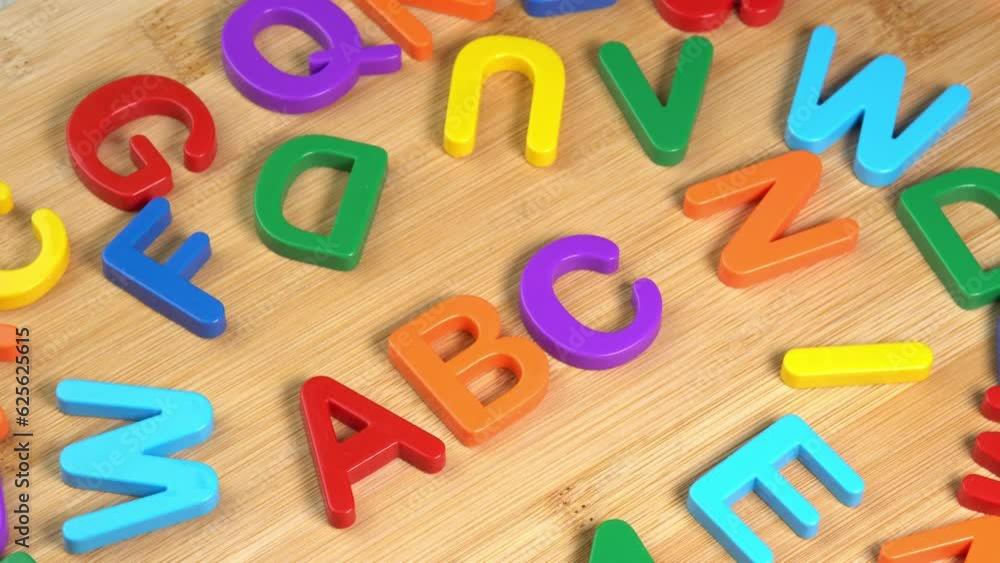 Colorful ABC Alphabet letters rotate on a wooden background. The concept of learning, school or college and knowledge. Plastic English letters, Latin Colorful ABC Alphabet letters rotate on a wooden background. The concept of learning, school or college and knowledge. Plastic English letters, Latin