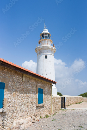 Beautiful landscape with white Paphos Lighthouse  blue sky and green grass  white clouds