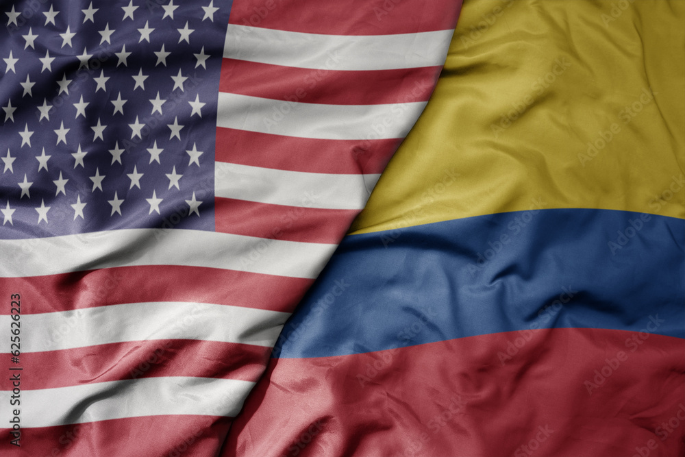 Obraz premium big waving colorful flag of united states of america and national flag of colombia .