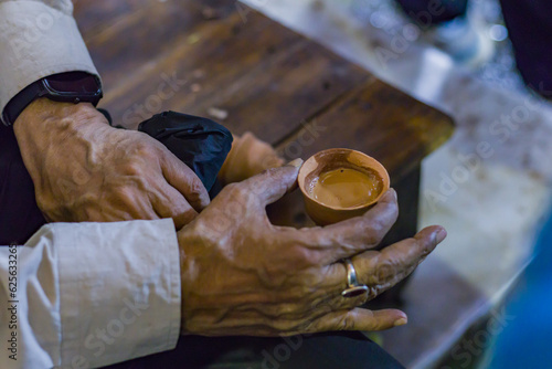 Photography Tea in a clay pot is held by hand for drinking
