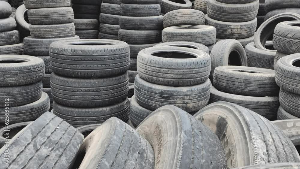 A large pile of old used tires in an auto repair shop where customers come in to replace their faulty tires. concept of recycling used tires or making good use of old tires. A large pile of old used tires in an auto repair shop where customers come in to replace their faulty tires. concept of recycling used tires or making good use of old tires.