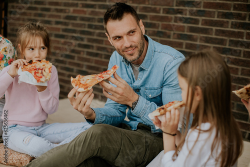 Young family eating pizza i...