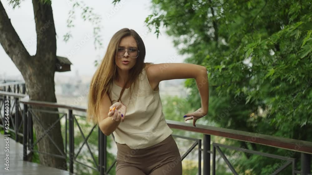 On the observation deck, a girl dances with sheer elegance, her movements echoing the dynamic cityscape that surrounds her. High quality 4k footage On the observation deck, a girl dances with sheer elegance, her movements echoing the dynamic cityscape that surrounds her. High quality 4k footage
