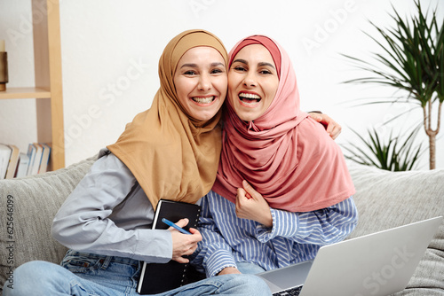 Photography Two women in traditional Muslim clothes are smiling