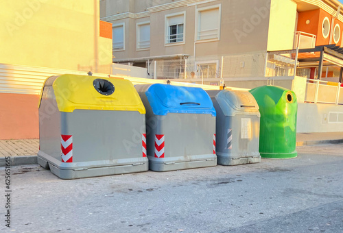 Garbage cans on street at building.  Garbage bins for rubbish. Garbage disposal to landfill. Sorting garbage and household food waste for recycling. Recycling of plastic waste. Sorting glass bottles. © MaxSafaniuk
