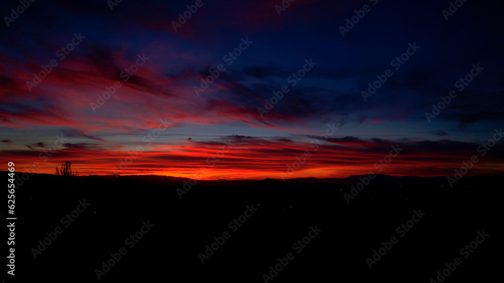Colorful sunset at golden hour. Sky on fire at sunset with vivid colors from blue to red. Palette of natural colors at sunset. Granada. Andalusia. Spain.