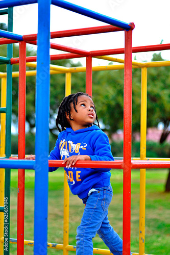  beautiful young black African boy with dreadlocks playing in a park . © Luckmore