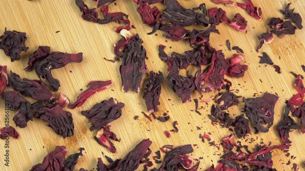 Vidéo Stock Hibiscus tea leaves rotate on wooden table. Dried hibiscus ...