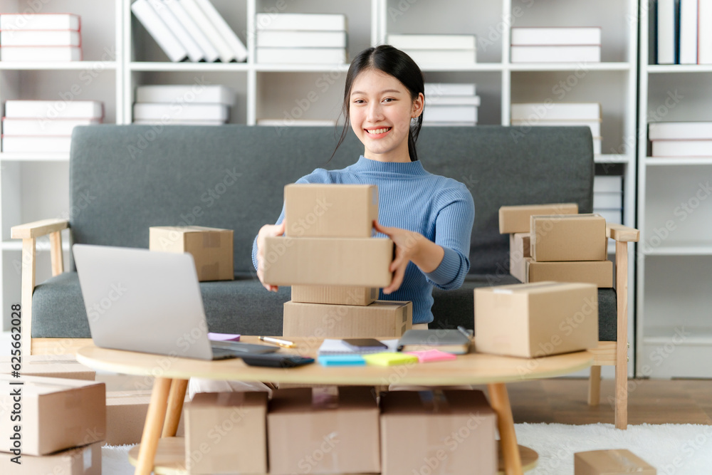 Young business owner woman prepare parcel box and standing check online orders for deliver to customer on tablet, laptop Shopping Online concept. Young business owner woman prepare parcel box and standing check online orders for deliver to customer on tablet, laptop Shopping Online concept.
