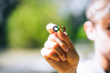 Autism infinity rainbow symbol sign in kid hand. World autism awareness day, autism rights movement, neurodiversity, autistic acceptance movement