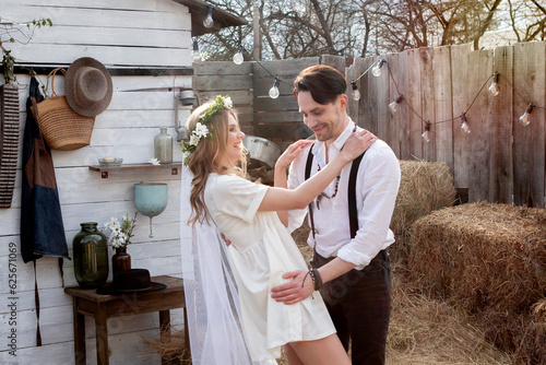 country bride in a white short dress and groom in a white shirt in the village wedding, boho style.
