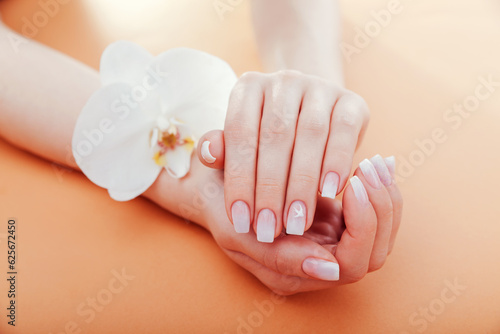 фотографія Ombre french manicure with orchid on orange background