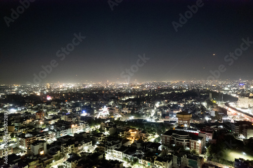 aerial drone tripod shot showing cityscape of jaipur delhi with fireworks  rockets  pyrotechnics and sky lanterns at night in celebration of makar sankranti  independence republic day and diwali in In